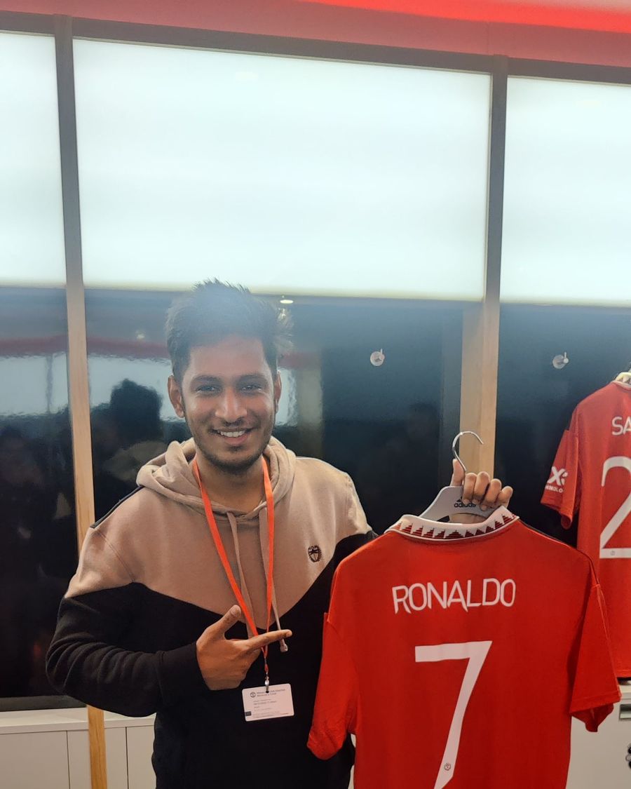 Satyam Chourey holding a Manchester United shirt at Old Trafford